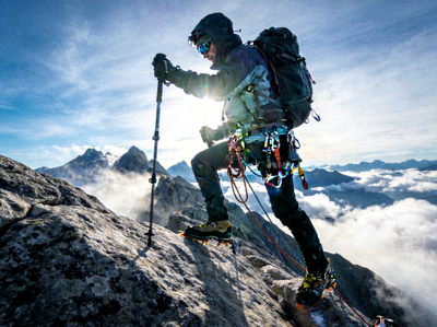 户外登山者在山脊上使用登山装备的场景